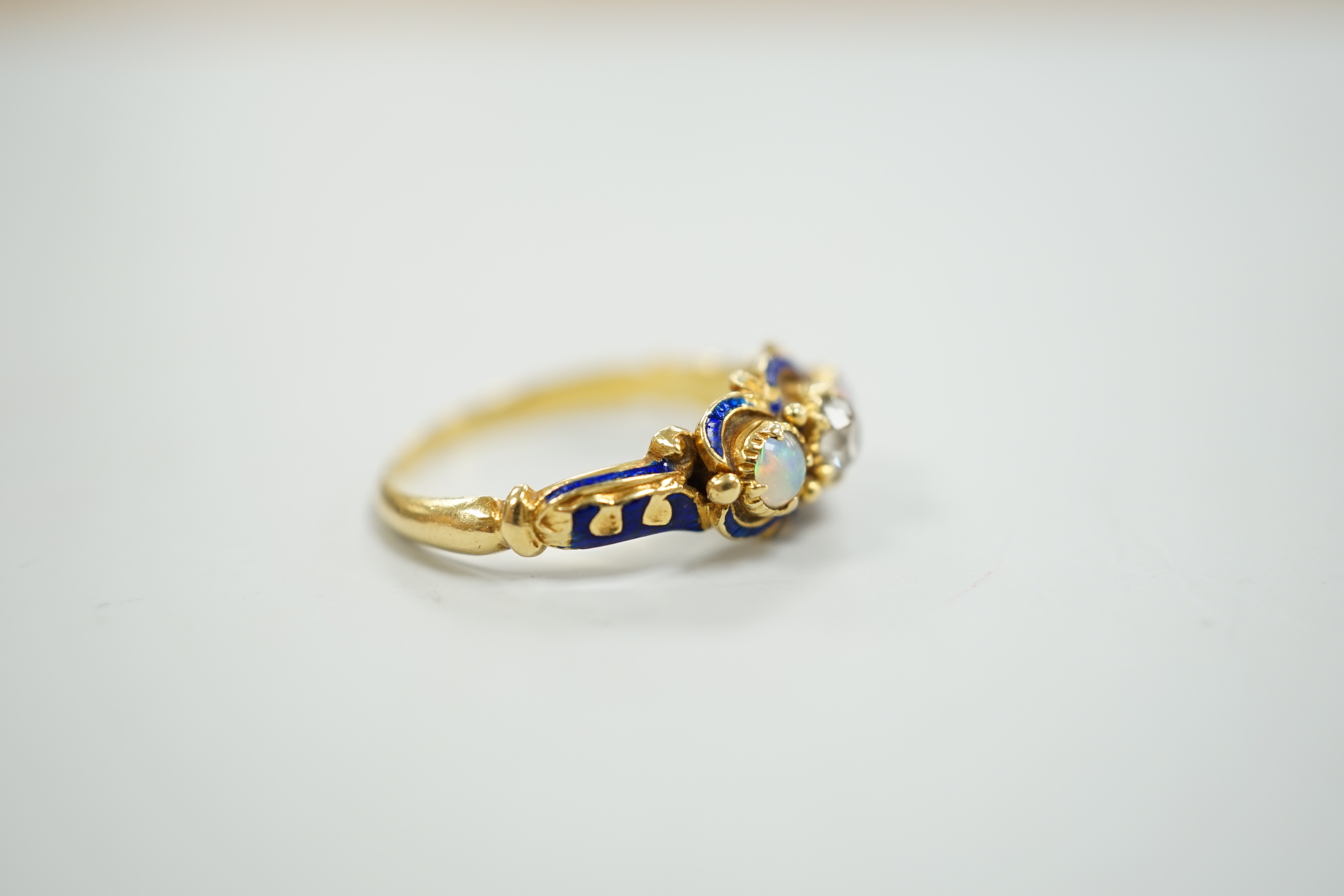 A late Victorian yellow metal, single stone diamond, two stone opal and enamelled dress ring, size K, gross weight 3 grams.